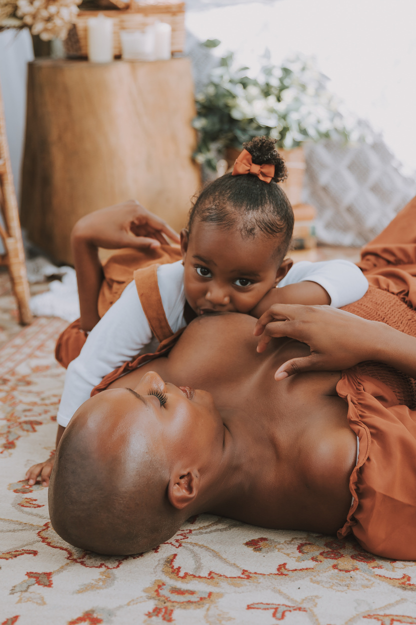 Mother Breastfeeding a Baby Daughter while Lying on the Floor